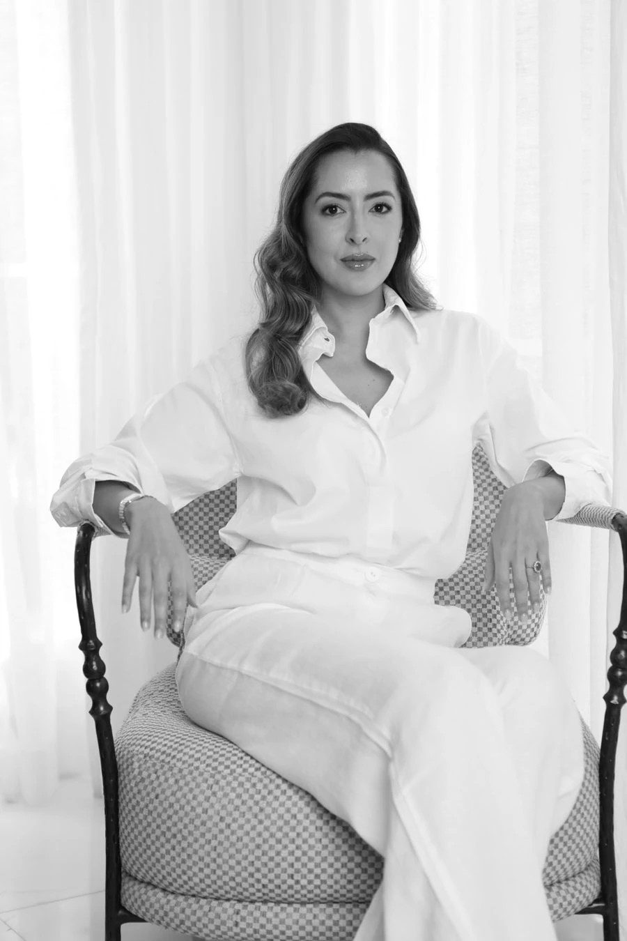 María José Álvarez Betín sentada en una silla, vestida de blanco
